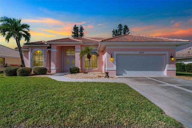 mediterranean / spanish-style home with a garage and a yard