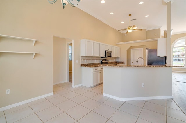 kitchen with white cabinetry, appliances with stainless steel finishes, light tile patterned flooring, and stone counters