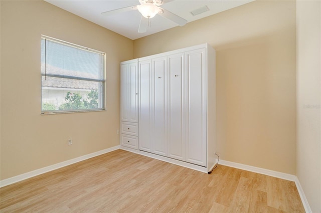 unfurnished bedroom with ceiling fan and light wood-type flooring