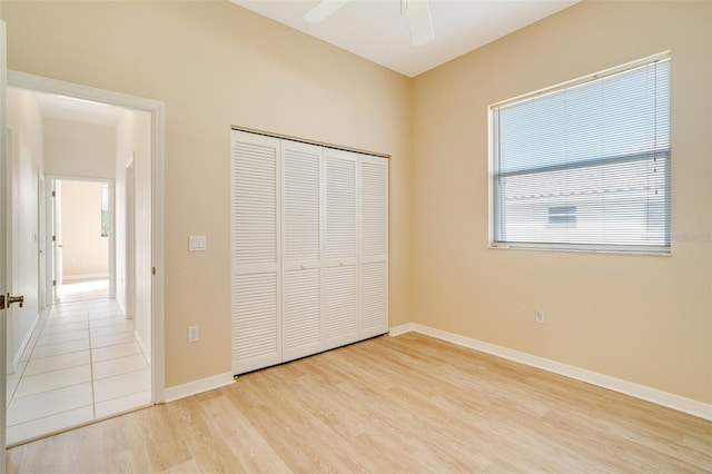 unfurnished bedroom featuring light hardwood / wood-style floors, ceiling fan, and a closet