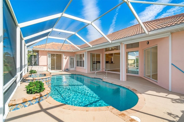 view of swimming pool with an in ground hot tub, ceiling fan, glass enclosure, and a patio area