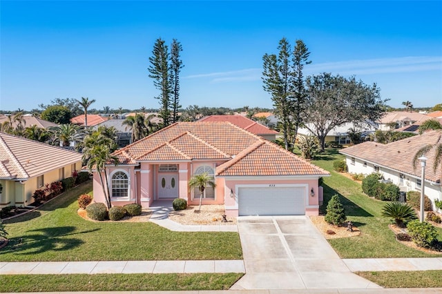 mediterranean / spanish-style house featuring a garage and a front lawn