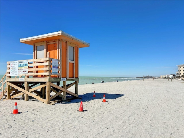 exterior space featuring a water view and a beach view