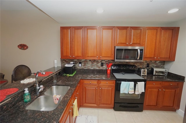 kitchen with backsplash, black / electric stove, dark stone countertops, and sink