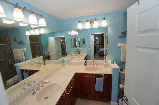 bathroom with tile patterned floors, vanity, and a shower with shower door