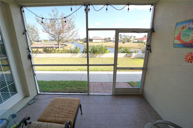 doorway featuring plenty of natural light, a water view, and tile patterned flooring