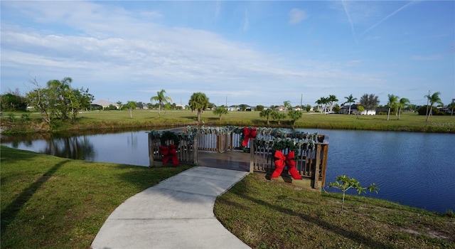 view of dock featuring a lawn and a water view