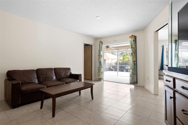 living room with a textured ceiling and light tile patterned flooring