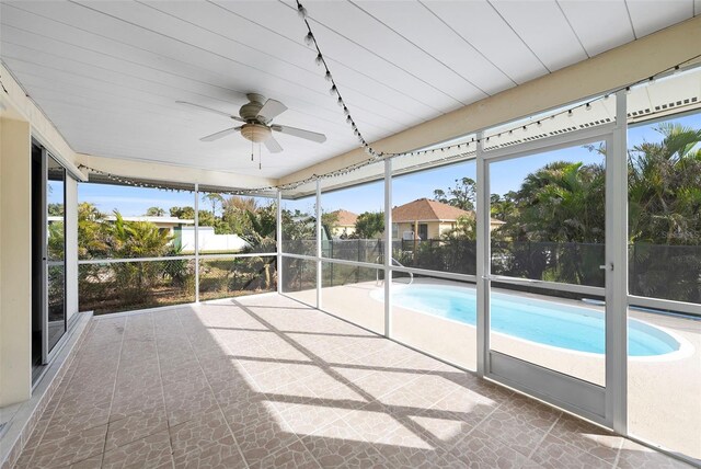 unfurnished sunroom featuring ceiling fan