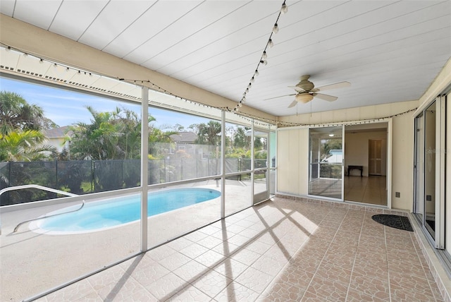 unfurnished sunroom featuring track lighting and ceiling fan