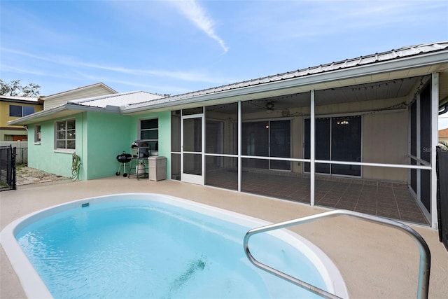 view of pool with area for grilling, a sunroom, and a patio