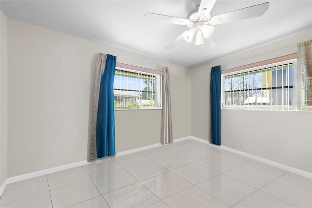 unfurnished room with ceiling fan, a textured ceiling, and light tile patterned floors