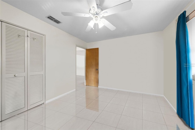 unfurnished bedroom featuring light tile patterned floors, a closet, and ceiling fan