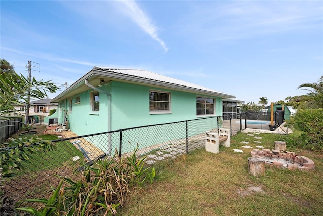 view of home's exterior with a fenced in pool and a lawn