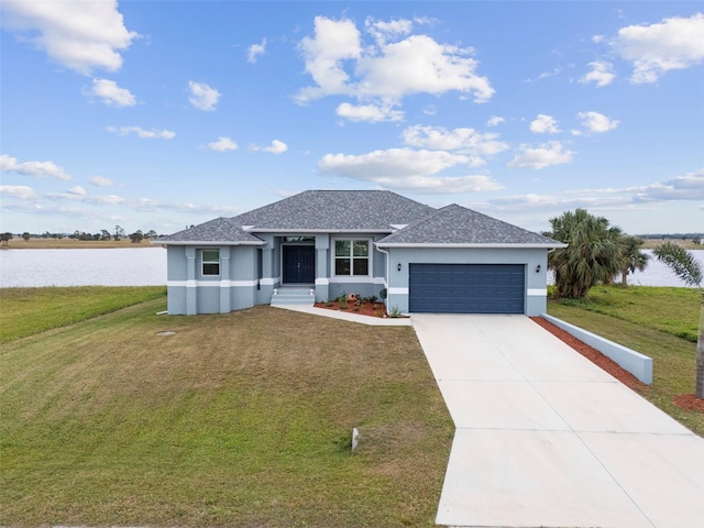 view of front facade featuring a garage, a front lawn, and a water view