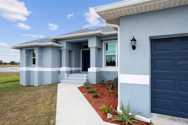 entrance to property with a yard and a garage