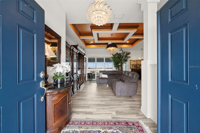 entryway with ornamental molding, coffered ceiling, a notable chandelier, beam ceiling, and light hardwood / wood-style flooring