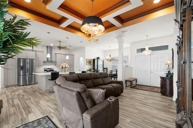 living room featuring coffered ceiling, crown molding, light hardwood / wood-style flooring, and decorative columns