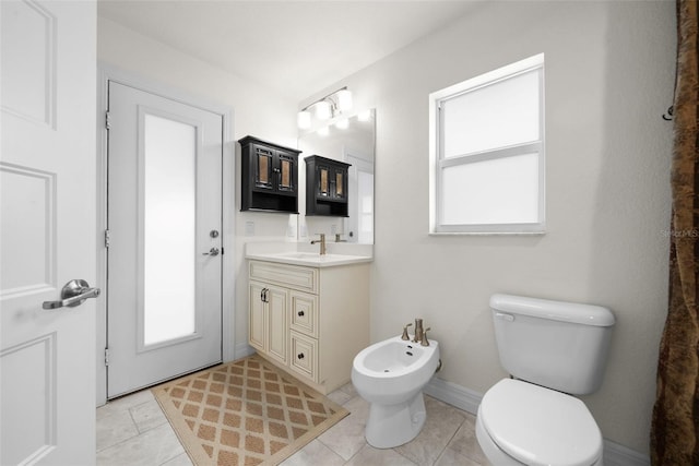 bathroom with a bidet, vanity, tile patterned floors, and toilet