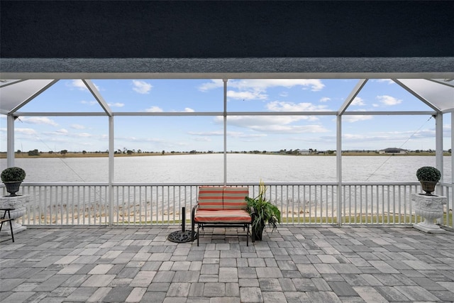 view of patio / terrace featuring a water view and a lanai