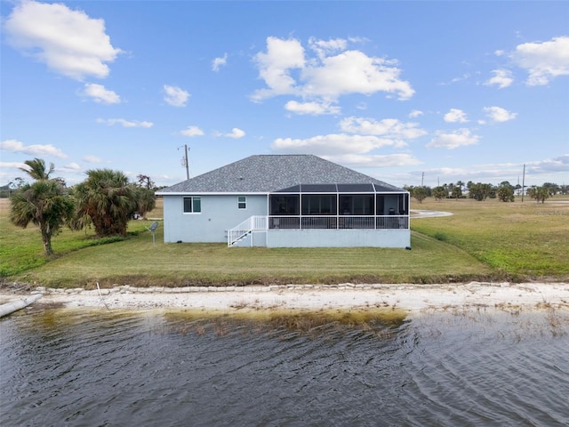 rear view of house featuring a lawn and a water view