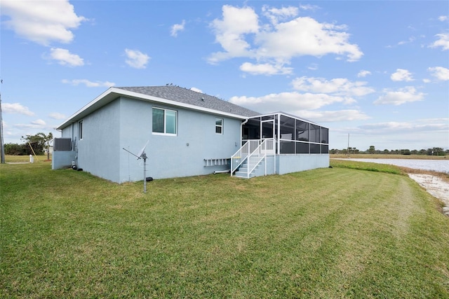 back of house featuring a water view, a lanai, and a lawn