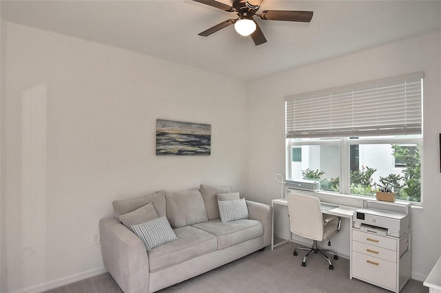 carpeted home office featuring ceiling fan