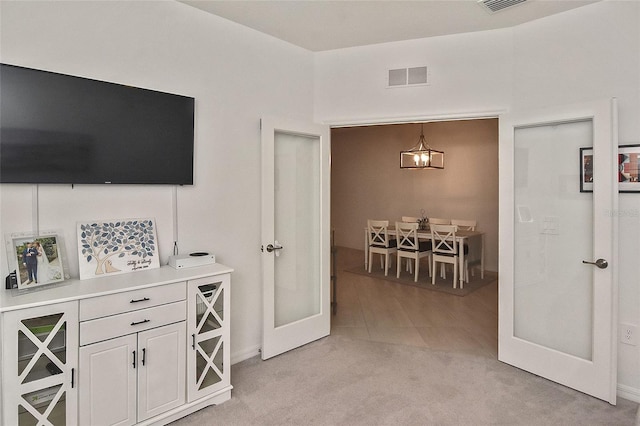 interior space with french doors and light colored carpet