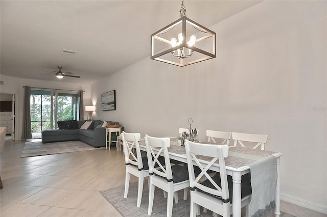 tiled dining space featuring ceiling fan with notable chandelier