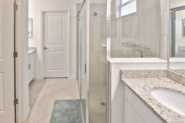 bathroom with tile patterned flooring, vanity, and a shower with shower door