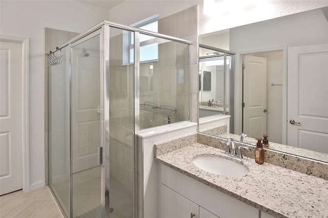 bathroom featuring tile patterned flooring, vanity, and walk in shower