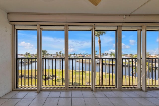 unfurnished sunroom featuring a water view and plenty of natural light