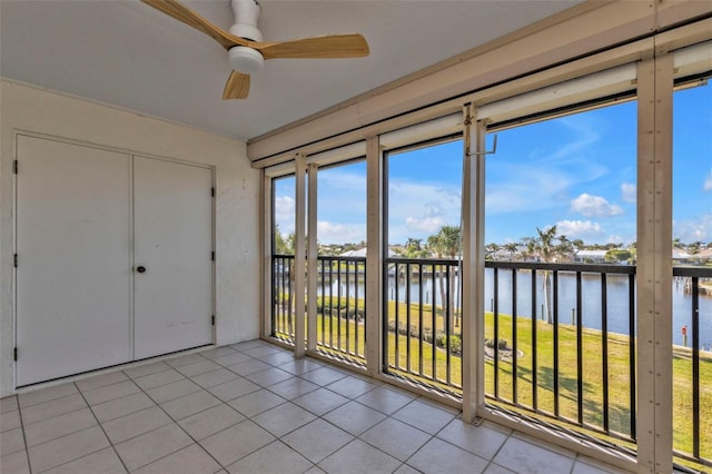 unfurnished sunroom with a water view and ceiling fan