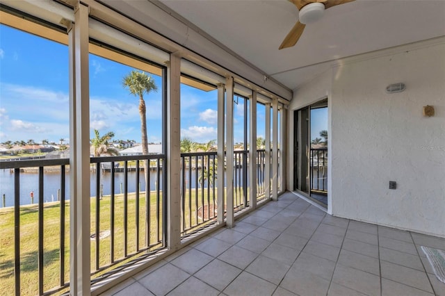 unfurnished sunroom with a water view and ceiling fan