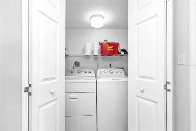 laundry room with independent washer and dryer and a textured ceiling