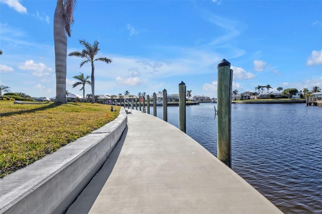 view of dock featuring a water view and a yard