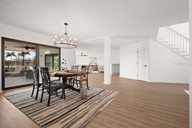 dining room with hardwood / wood-style flooring and ceiling fan with notable chandelier