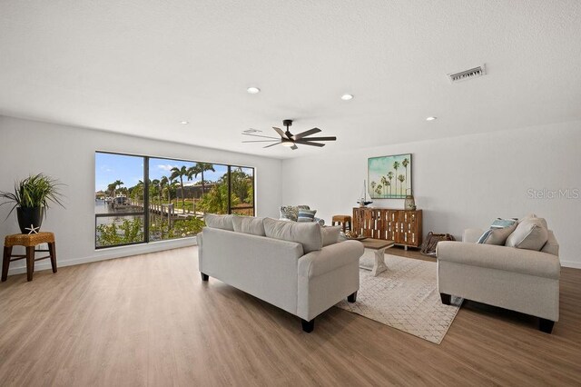 living room with hardwood / wood-style flooring and ceiling fan