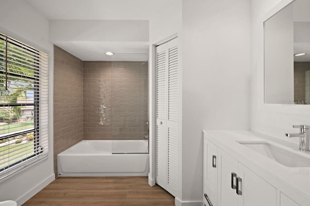 bathroom with vanity, hardwood / wood-style flooring, and tiled shower / bath combo