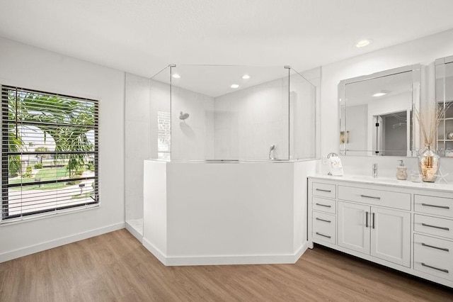 bathroom with vanity, hardwood / wood-style flooring, and walk in shower