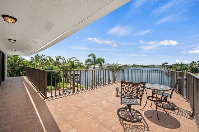 view of patio with a balcony and a water view