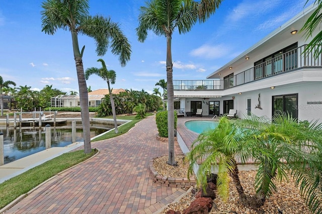 view of swimming pool with a water view and a patio area