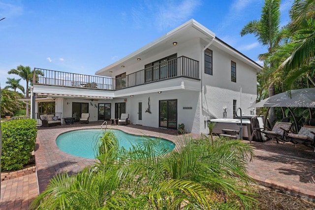 back of house featuring a balcony, a pool with hot tub, ceiling fan, and a patio