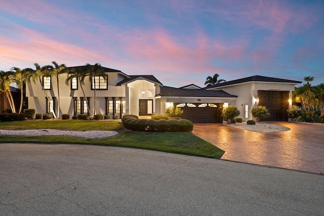 view of front of property with a garage and a yard