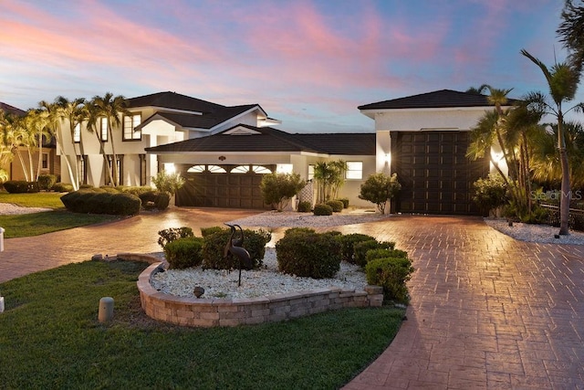 view of front of home with a garage and a lawn