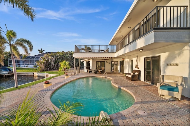 outdoor pool featuring a patio and a water view