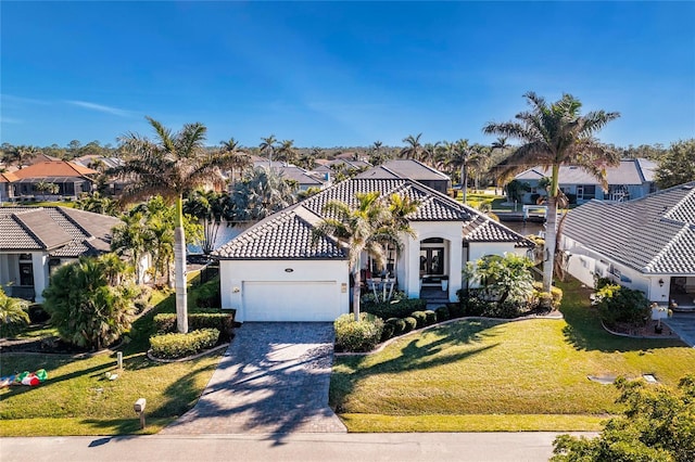 mediterranean / spanish house with a front lawn and a garage