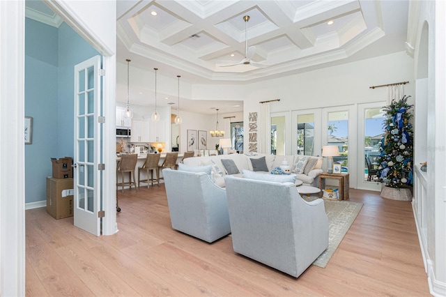 living room featuring french doors, a towering ceiling, crown molding, ceiling fan, and coffered ceiling