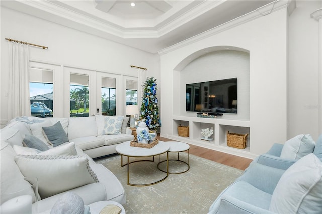 living room with coffered ceiling, french doors, ornamental molding, and hardwood / wood-style flooring