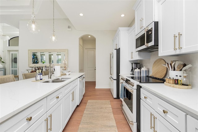 kitchen featuring white appliances, pendant lighting, white cabinetry, and sink